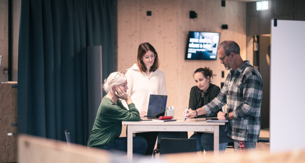 Vier Personen an einem Besprechungstisch