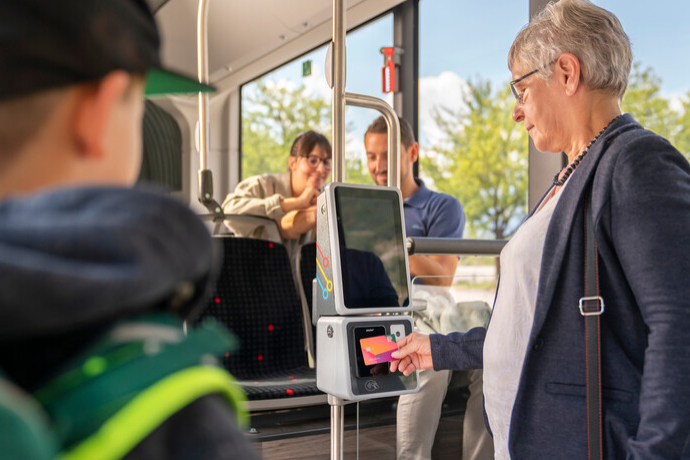Frau bezahlt im Bus mit Vendita