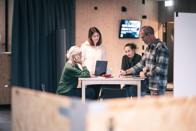 Vier Personen an einem Besprechungstisch