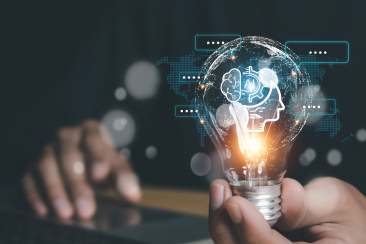 Hand hält eine Glühbirne mit digitaler Illustration eines Kopfes und Gehirns, Symbol für Künstliche Intelligenz, mit Logo topKMU